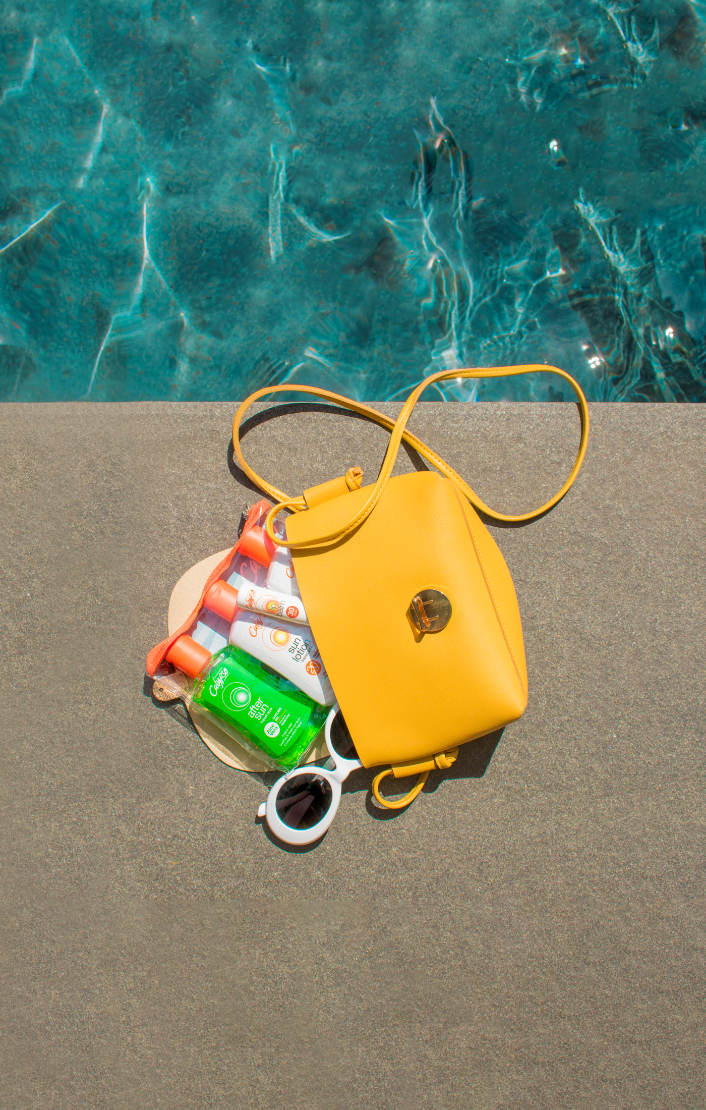 Calypso travel pack in a yellow bag near the pool